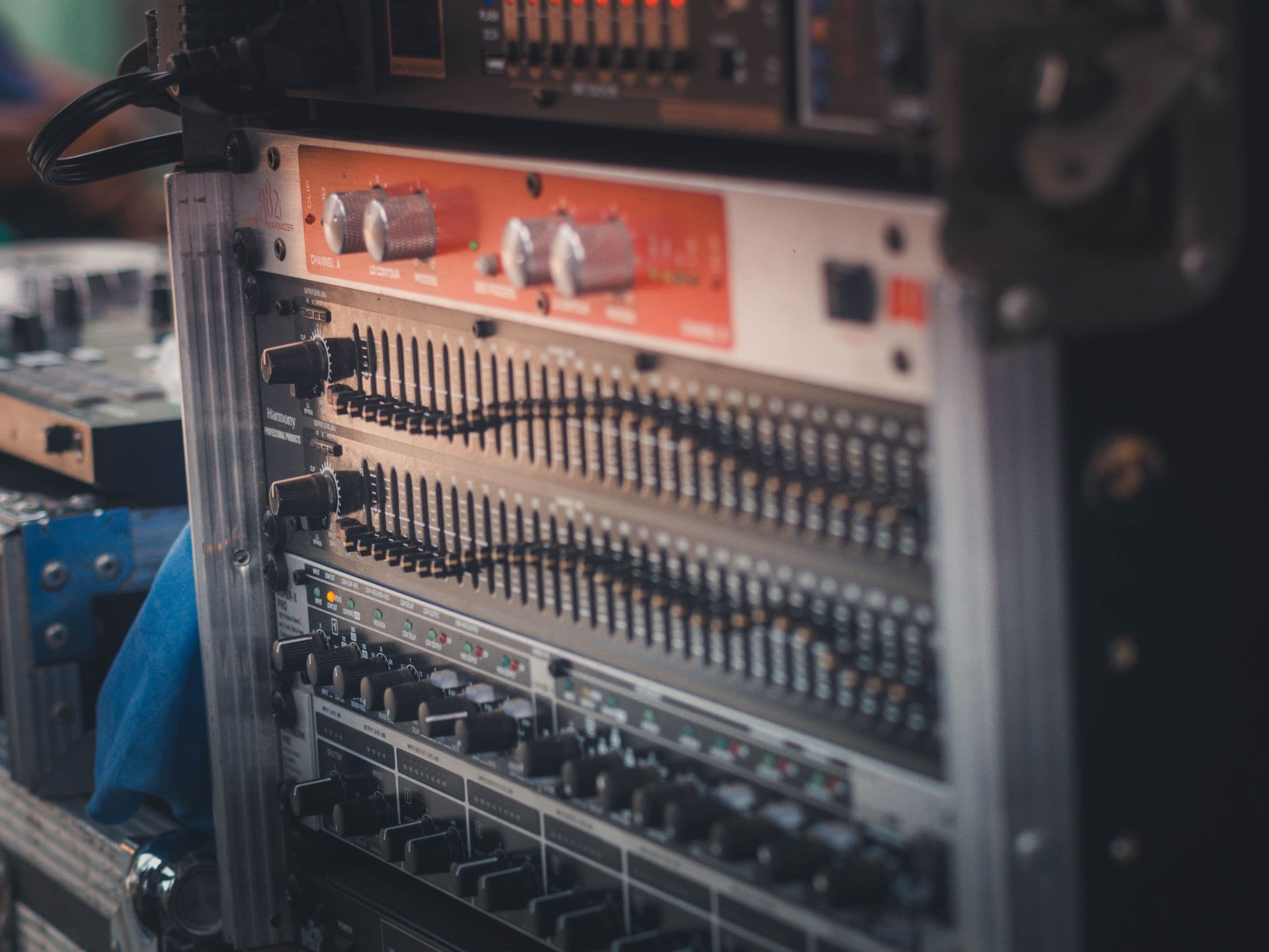 Rack of audio processing equipment with equalizers and amplifiers.