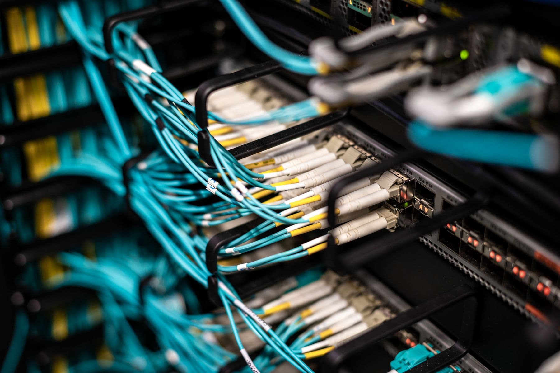 Fiber patch cables plugged into a rack of network equipment.