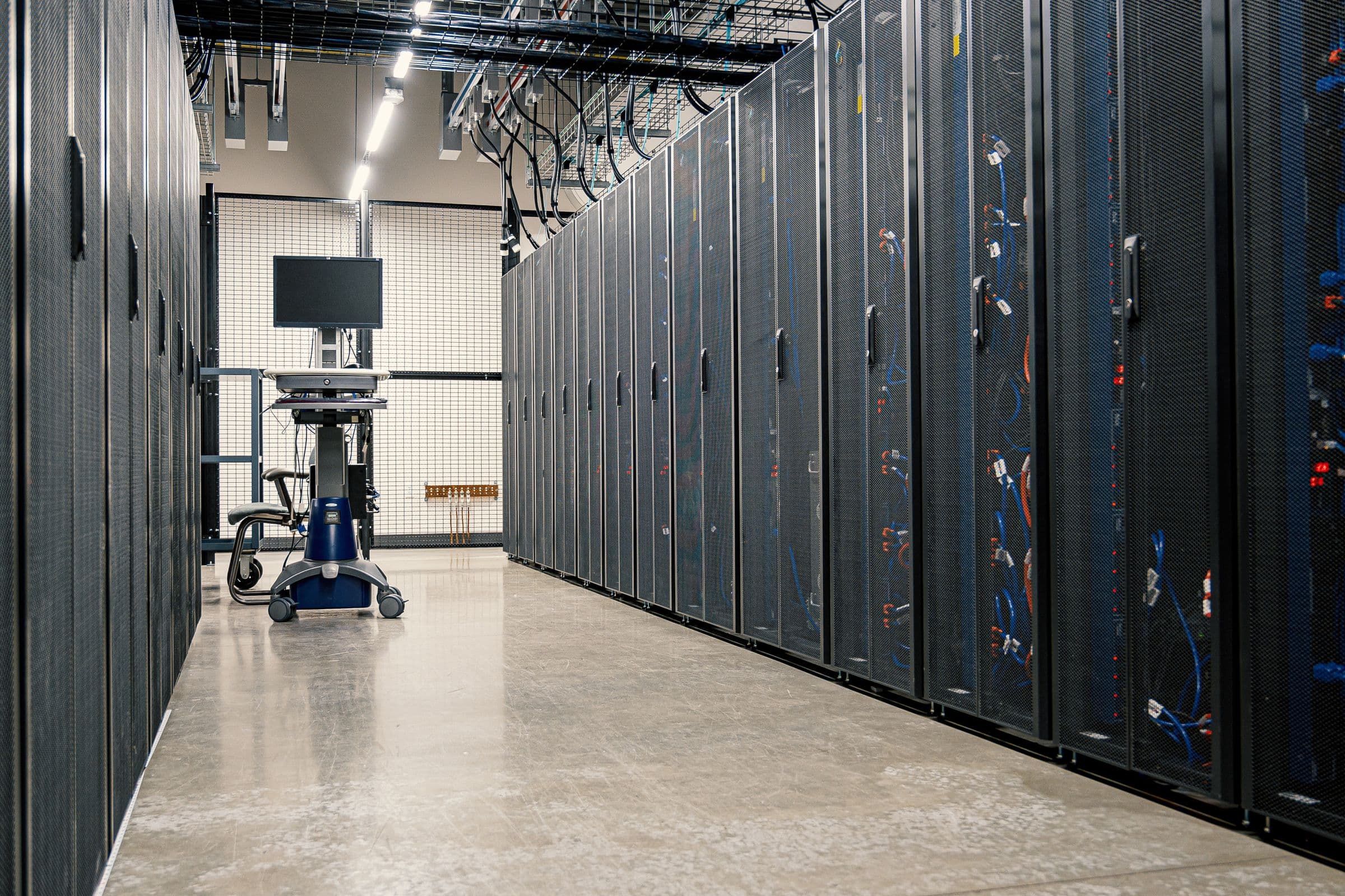 Aisle of enclosed server cabinets on a datacenter floor.